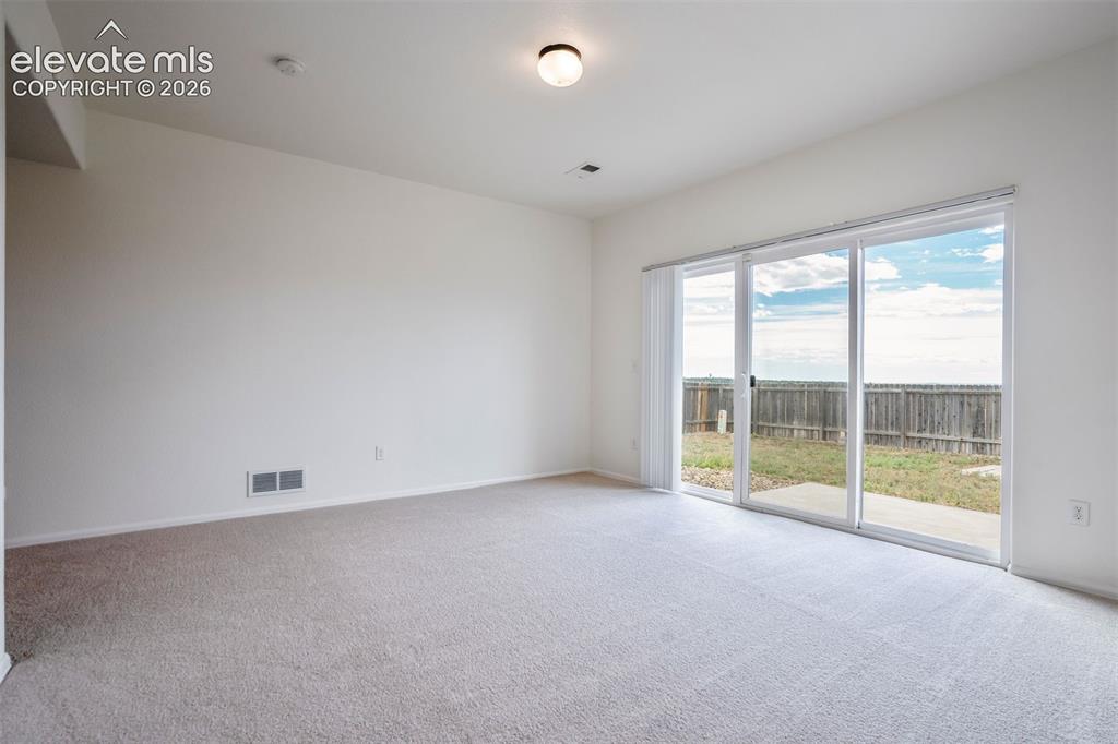 Image 16 of 39: Large sliding doors lead to the fenced backyard & allow plenty of natural l