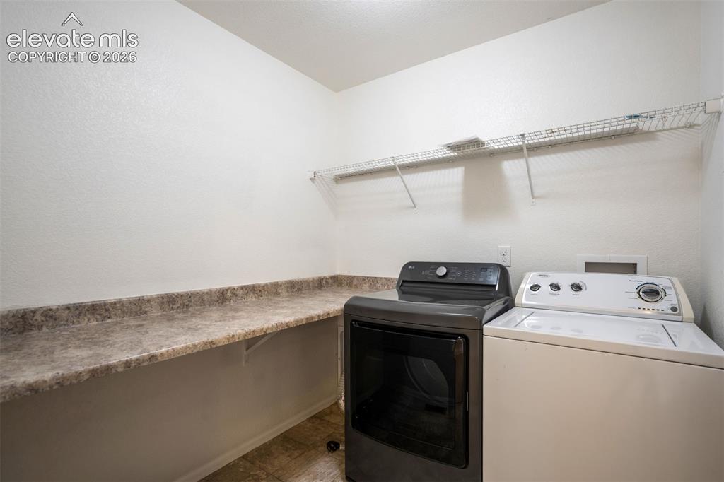 Image 33 of 39: Laundry Room with a folding table. 