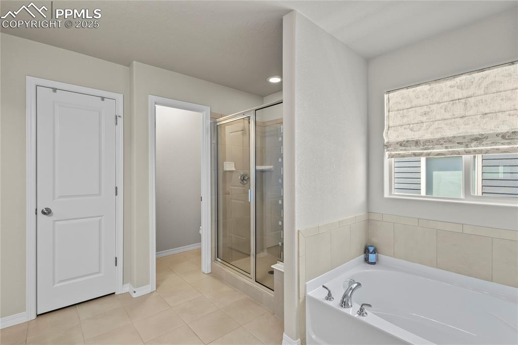 Image 22 of 47: Bathroom featuring a shower stall, a bath, and tile patterned flooring
