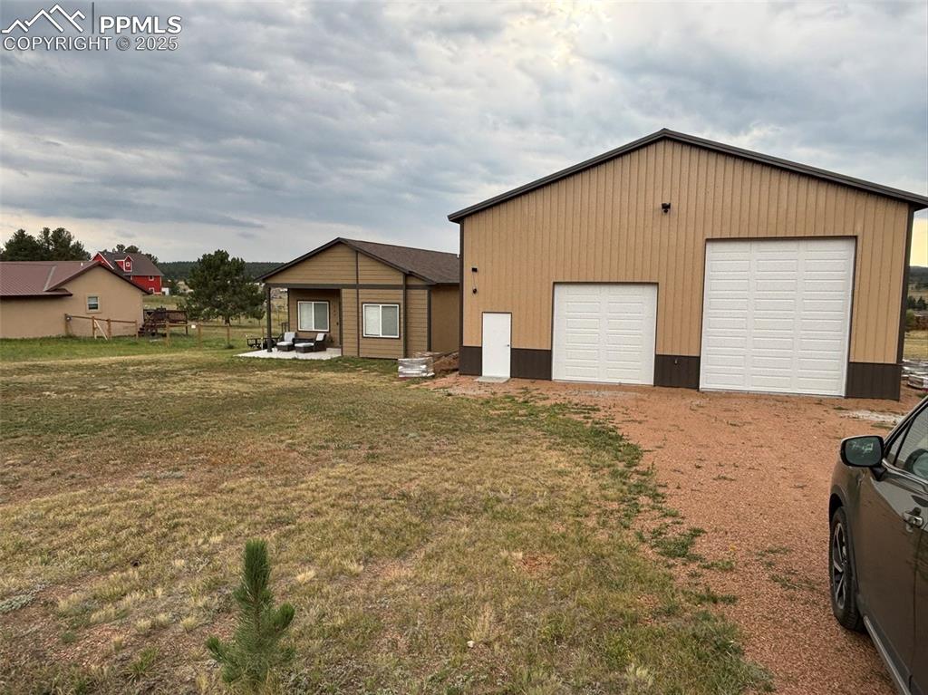 Image 19 of 29: View of front of home with a patio and an outbuilding