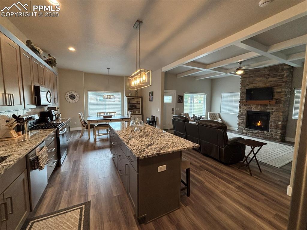 Image 4 of 29: Kitchen featuring coffered ceiling, beamed ceiling, decorative light fixtur