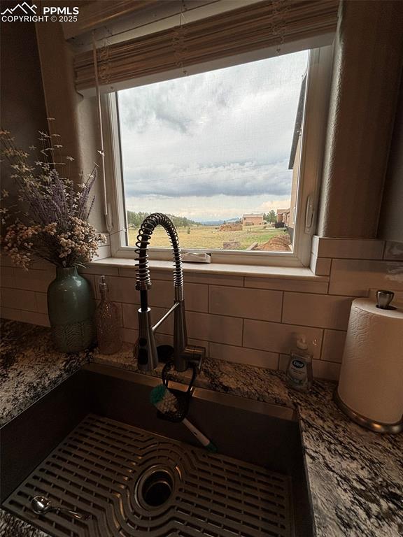 Image 9 of 29: Kitchen view of tasteful backsplash and dark stone counters