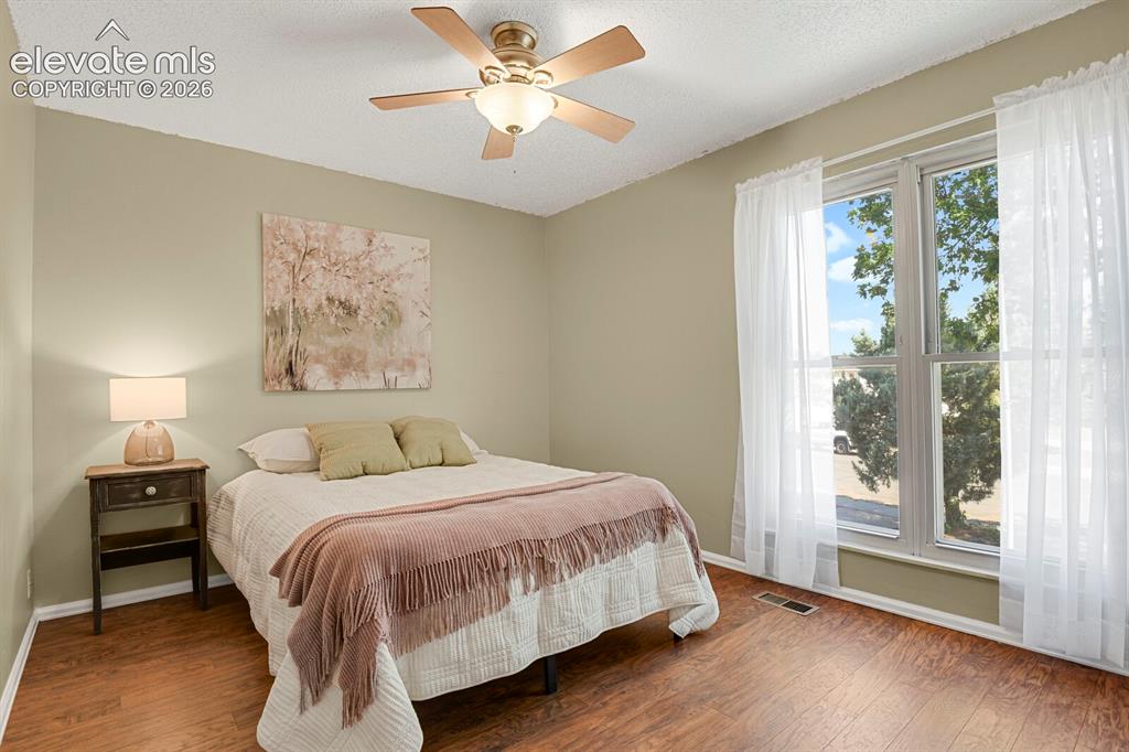 Image 19 of 28: Spacious interior with wood-finish flooring, a ceiling fan, and large windo