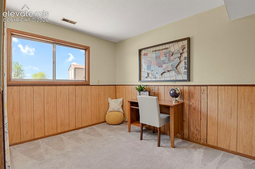 Image 21 of 28: Room featuring light wood-finish wainscoting, neutral wall paint, and soft