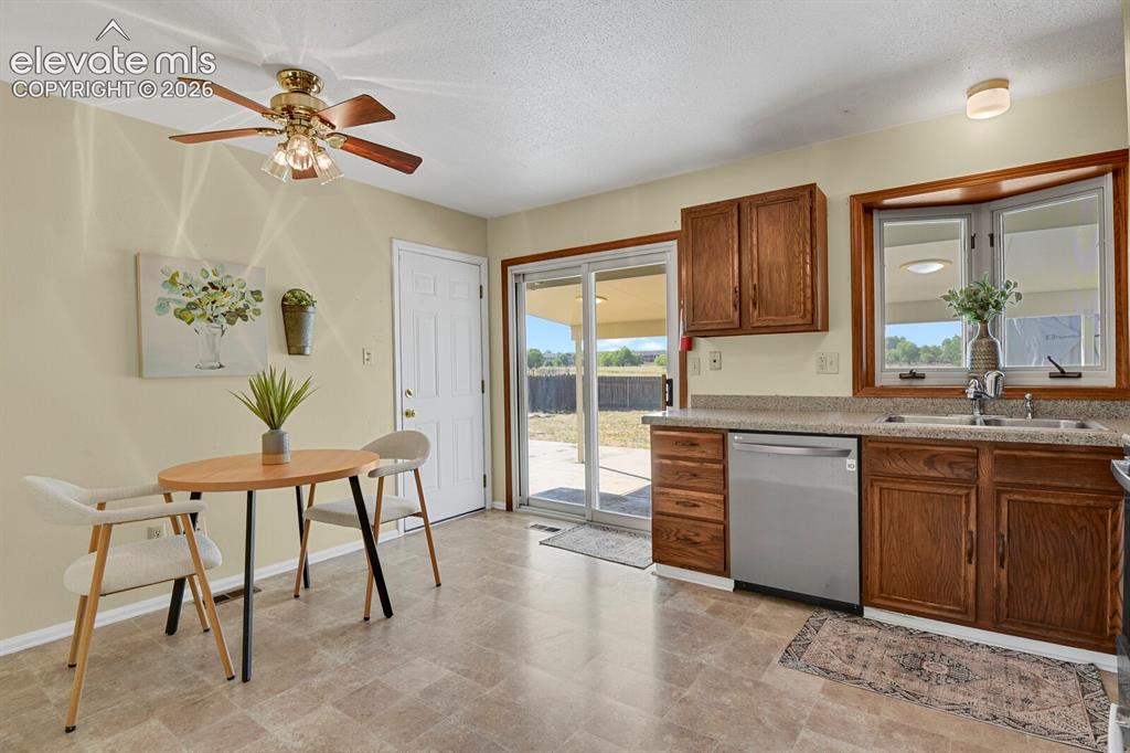 Image 9 of 28: Kitchen featuring wood cabinetry, a stainless steel dishwasher, and a doubl
