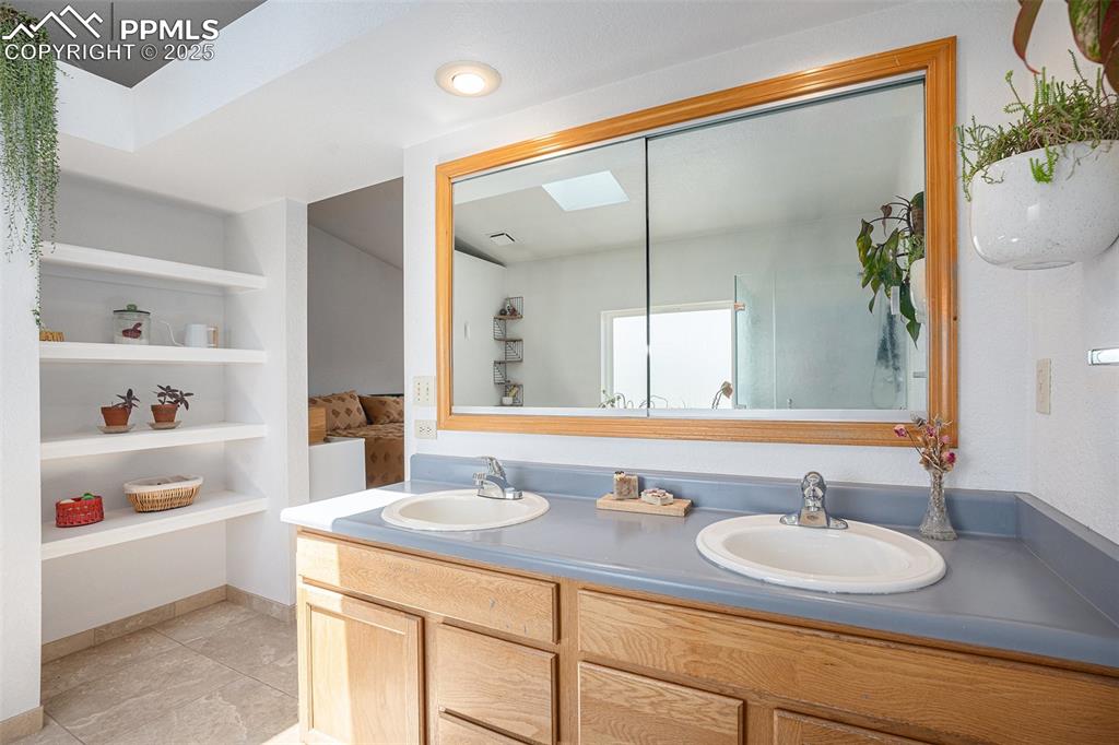 Image 11 of 27: Bathroom with double vanity and tile patterned floors