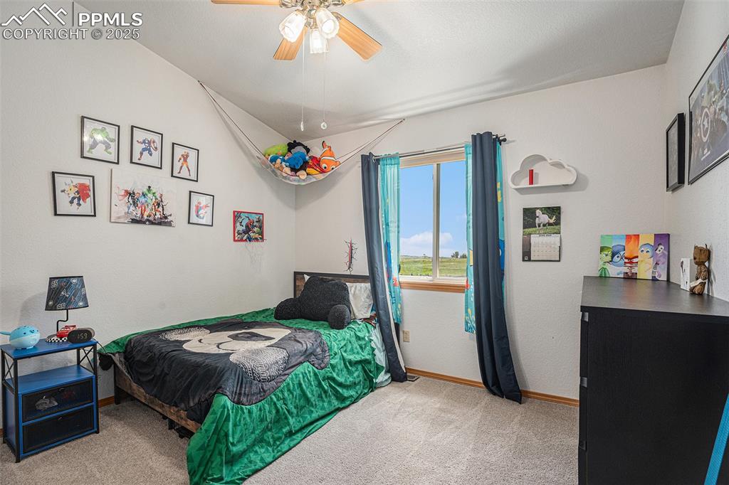 Image 13 of 27: Carpeted bedroom with baseboards and ceiling fan