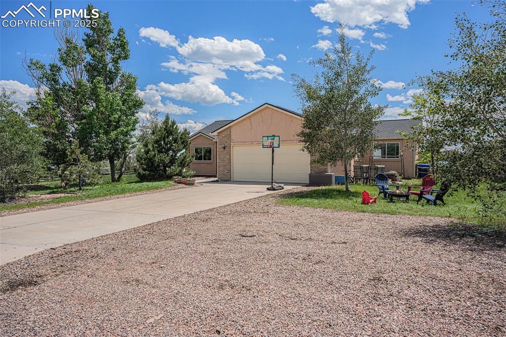 Image 23 of 27: View of front of house with brick siding, concrete driveway, and a garage