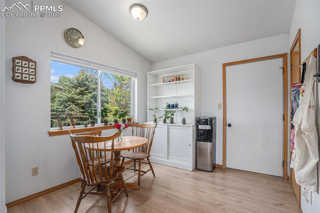 Image 3 of 27: Dining room with lofted ceiling and light wood-style floors