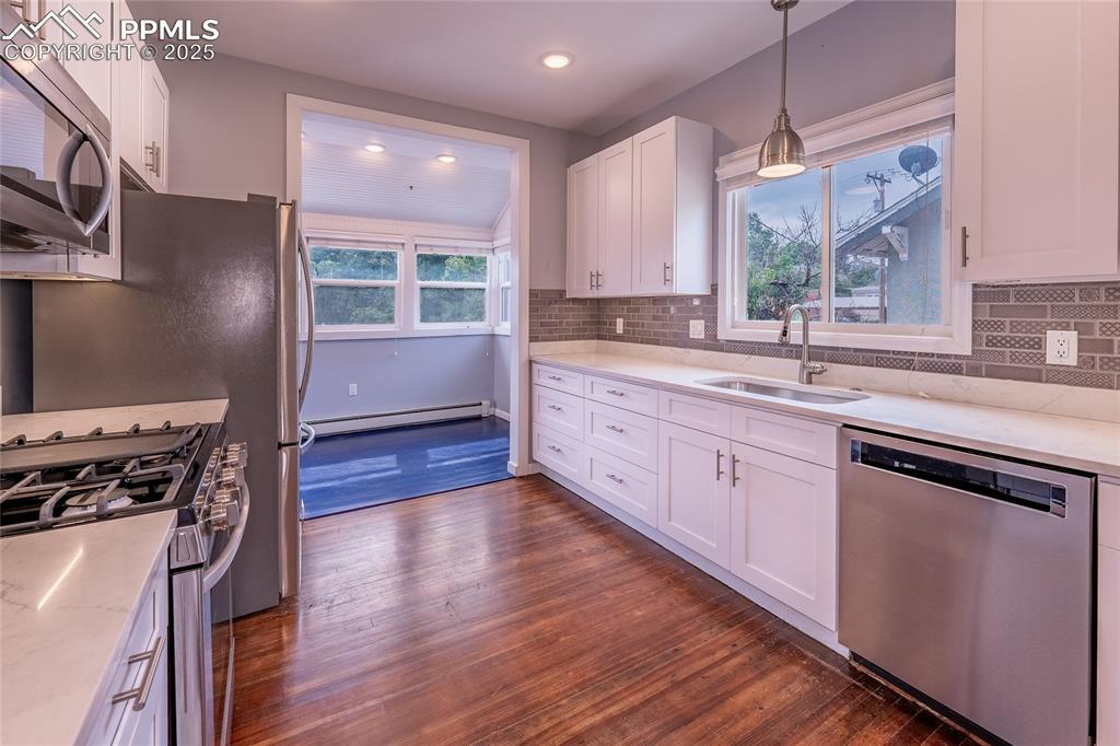 Image 14 of 49: Kitchen featuring appliances with stainless steel finishes, white cabinetry