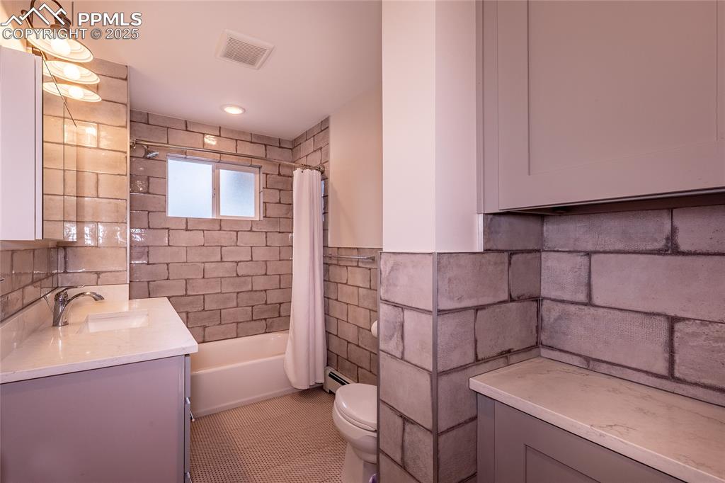 Image 15 of 49: Bathroom on main floor featuring shower / bath combo with shower curtain, v