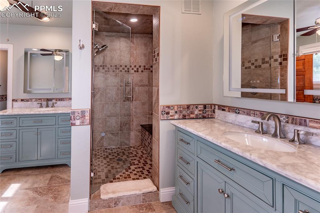 Image 19 of 49: Primary bathroom with a ceiling fan, a steam shower, under tile heating and
