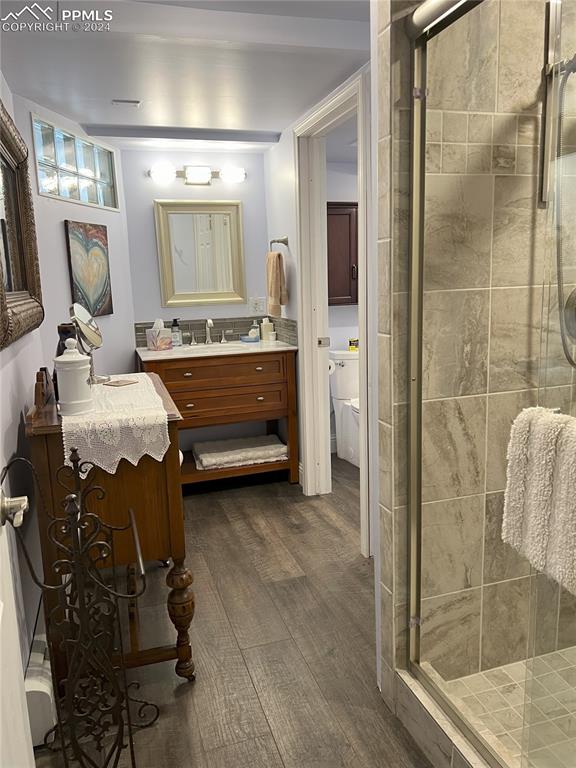 Image 24 of 49: Bathroom with hardwood / wood-style flooring, vanity, and walk in shower