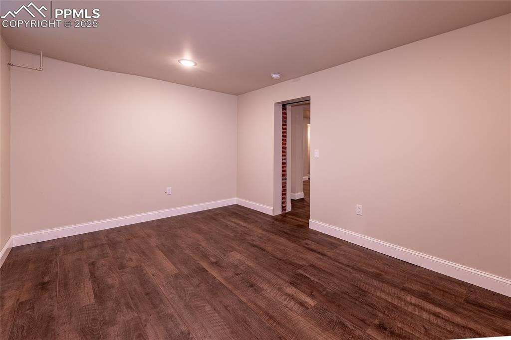 Image 26 of 49: Lower level bedroom with dark wood-style flooring and recessed lighting