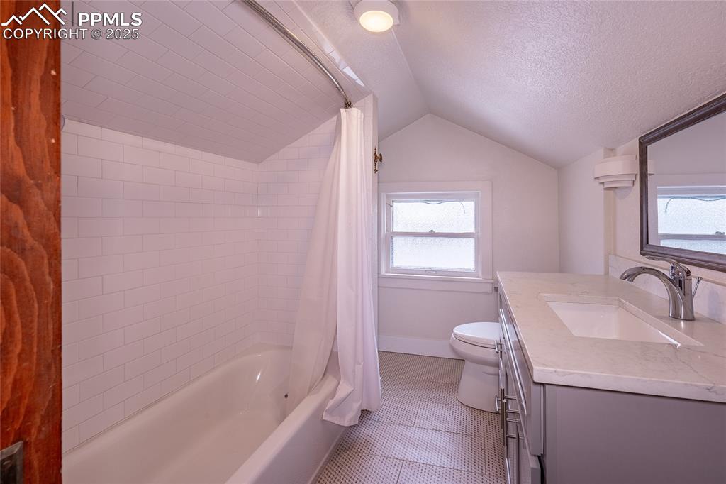 Image 31 of 49: Upstairs bathroom featuring shower / tub combo with curtain, vanity, vaulte