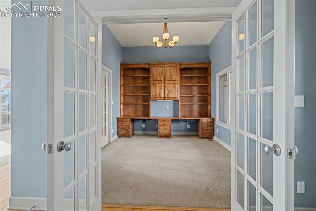 Image 13 of 44: Office with built-in shelves and desk.