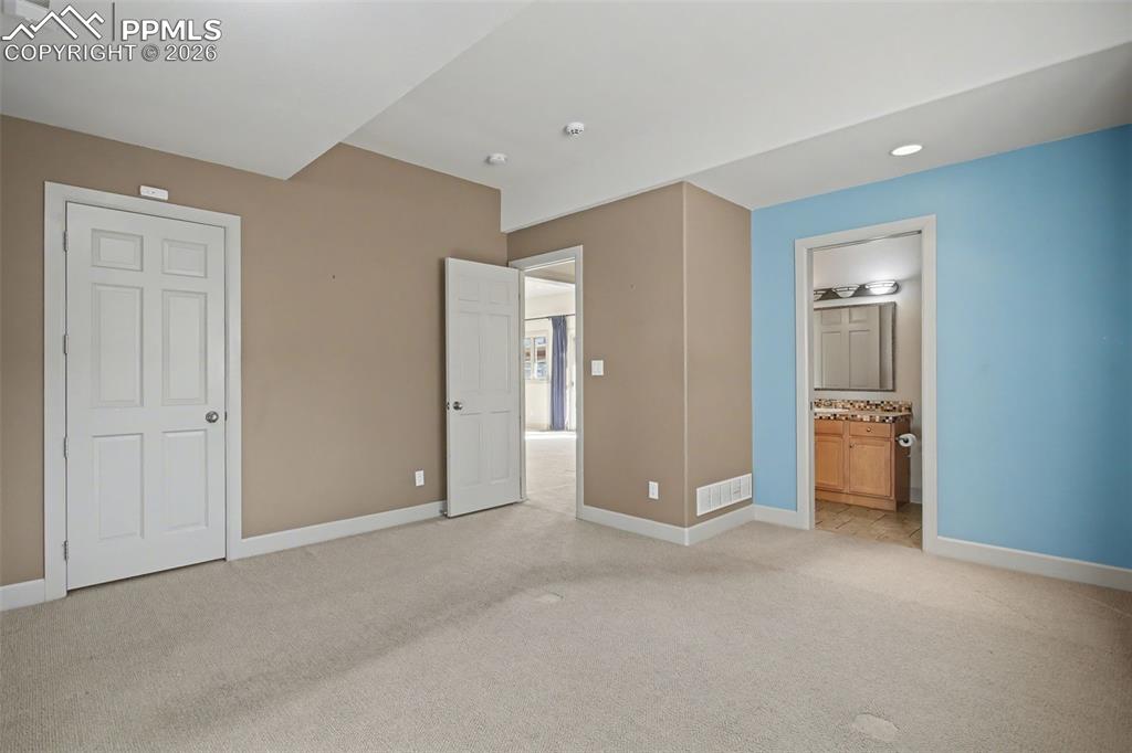 Image 25 of 44: Basement bedroom number #2 with view of adjoining bathroom. 