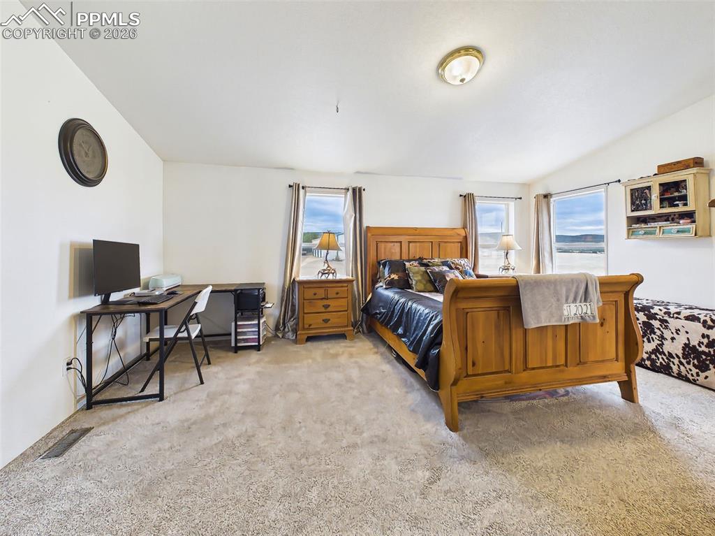 Image 21 of 50: Primary Bedroom – Overview – Spacious primary suite with large windows fram