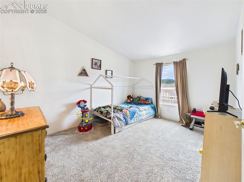 Image 27 of 50: Bedroom – Comfortable secondary bedroom with soft carpet, natural light, an