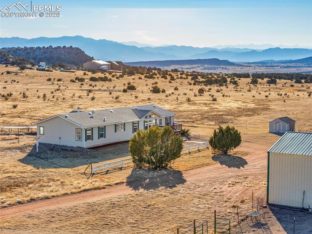 Image 32 of 50: Aerial View – Home, Outbuilding & Mountain Range – Elevated perspective sho