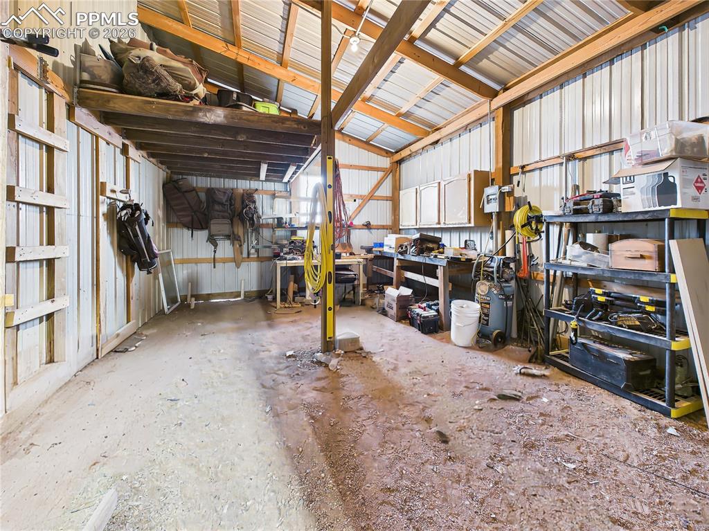 Image 43 of 50: Shop Area – Workbench Space – Dedicated workshop area with built-in shelvin