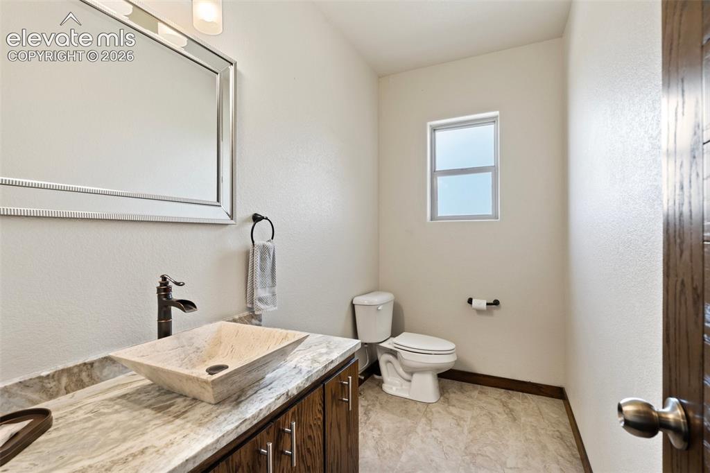 Image 21 of 46: Bathroom featuring a vessel sink with a dark bronze faucet, a vanity with w