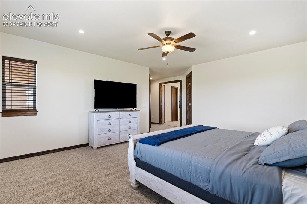 Image 26 of 46: Carpeted primary bedroom featuring recessed lighting, a ceiling fan with li