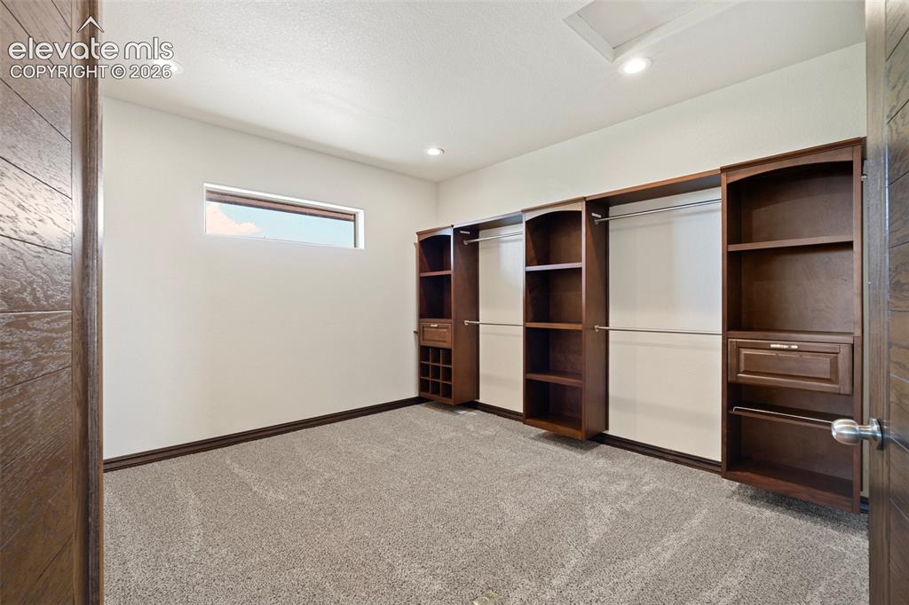 Image 32 of 46: Built-in custom cabinetry system featuring shelving, drawers, and hanging r