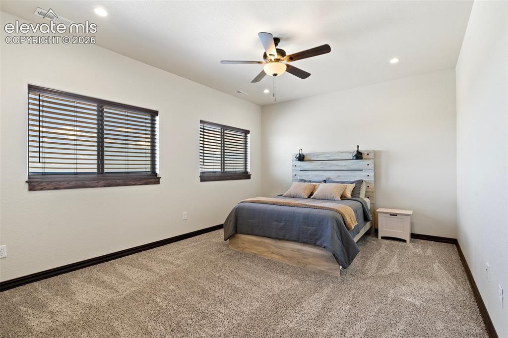 Image 35 of 46: Carpeted room featuring two windows with dark wood trim, recessed lighting,