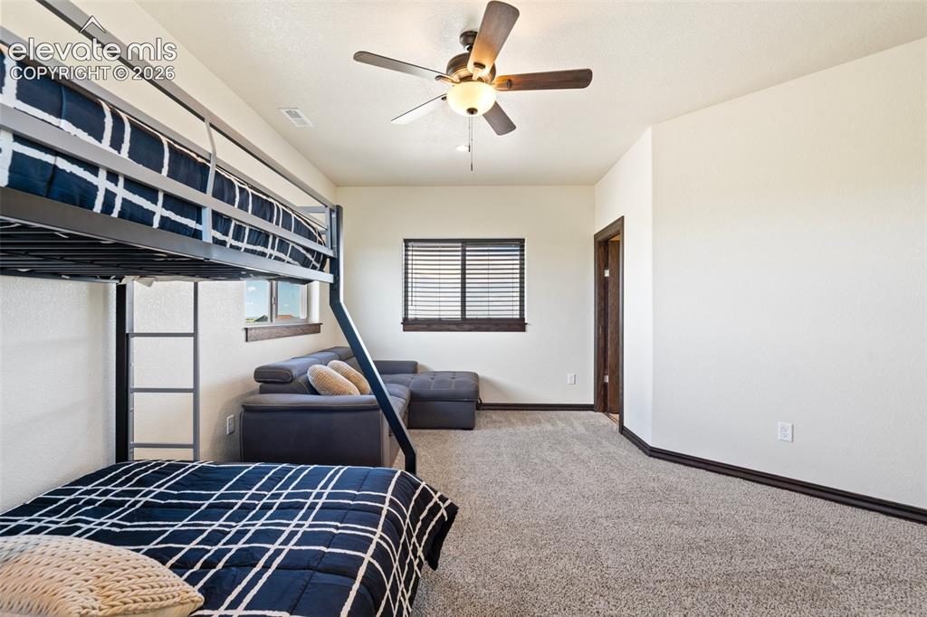 Image 38 of 46: Carpeted room featuring a ceiling fan with light fixture, a window with hor