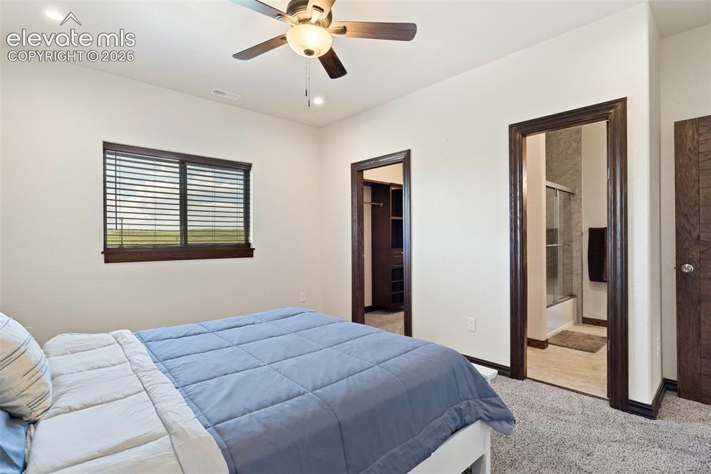 Image 40 of 46: Bedroom featuring neutral wall tones, dark wood-finish trim, a ceiling fan