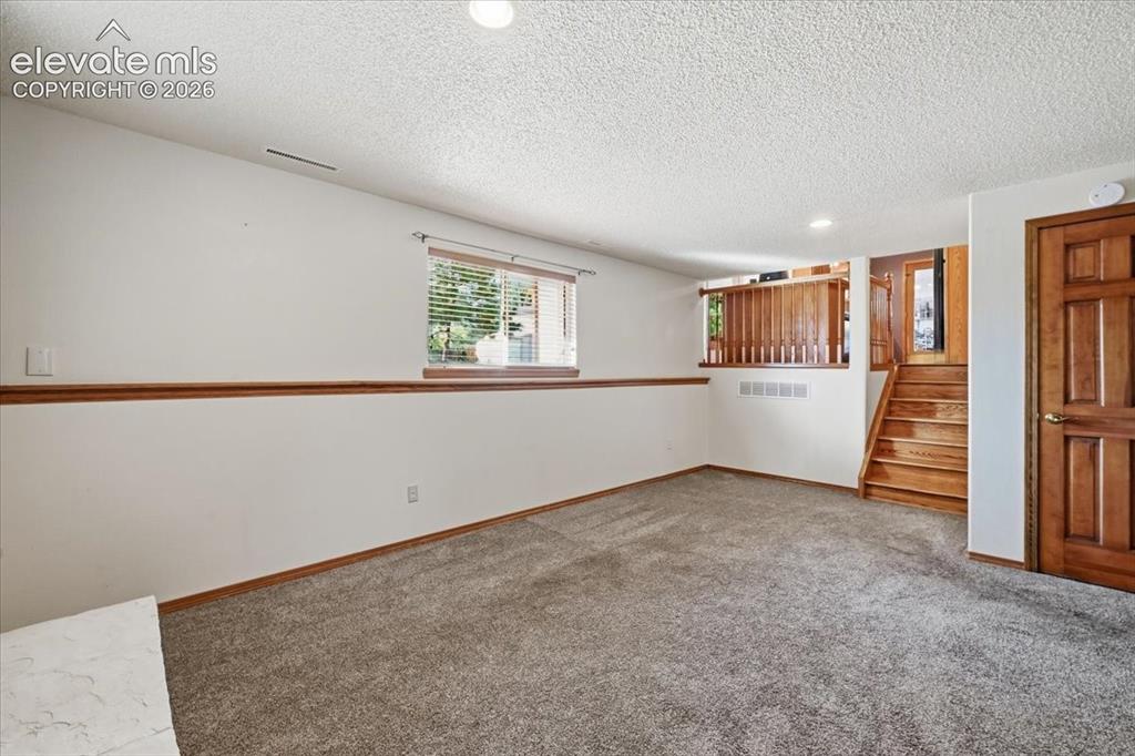 Image 15 of 25: Recessed ceiling lighting, wood-finish trim, wall-to-wall carpeting, wood-f