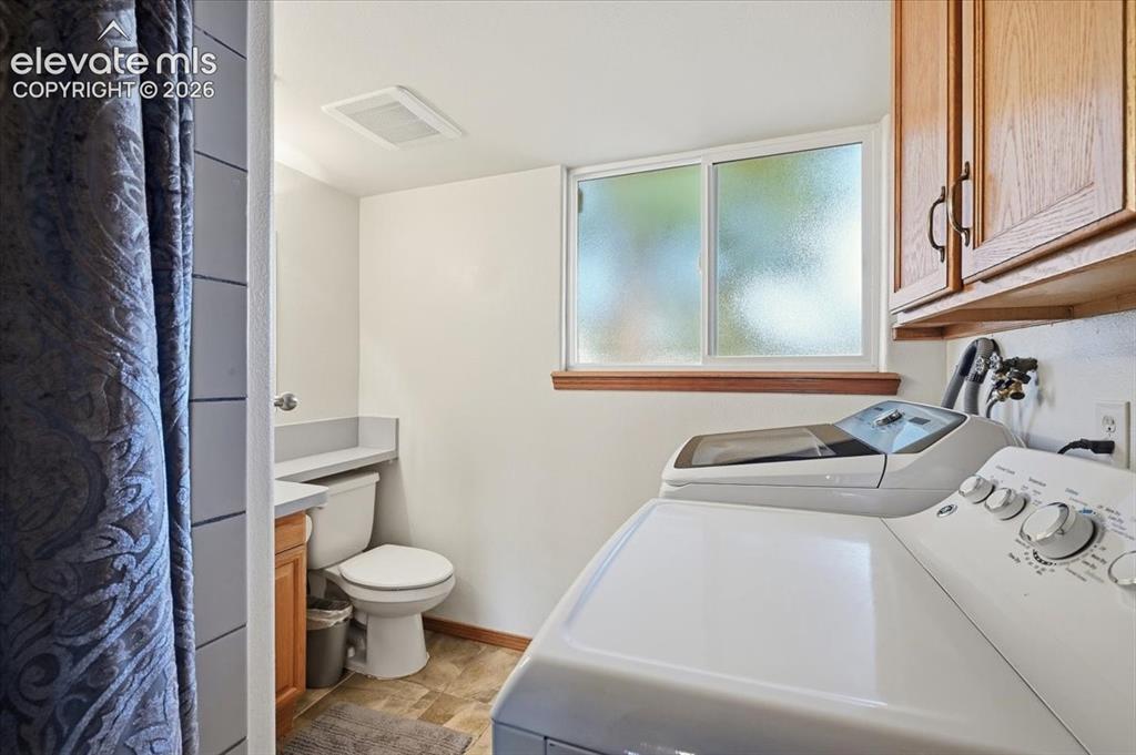 Image 19 of 25: Upper cabinetry with dark hardware, a horizontal sliding window, and wood-f