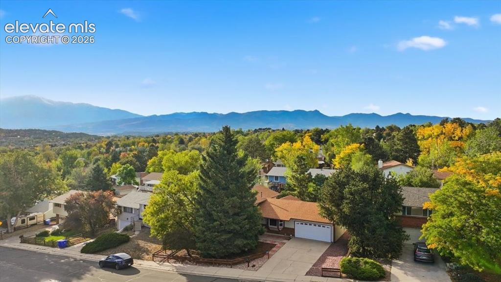 Image 24 of 25: Mountain backdrop, tree-lined neighborhood, residential street, concrete dr