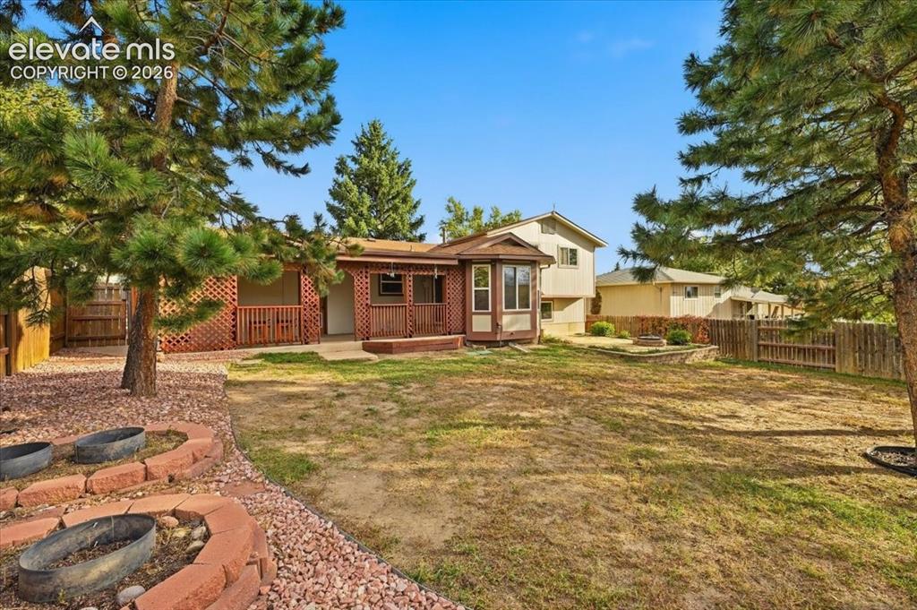 Image 25 of 25: Expansive backyard featuring a patio, a built-in fire pit, and mature trees
