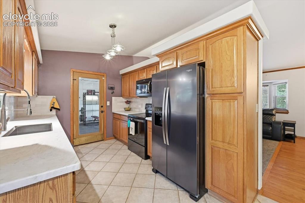 Image 8 of 25: Kitchen featuring wood cabinetry, white countertops, stainless steel refrig