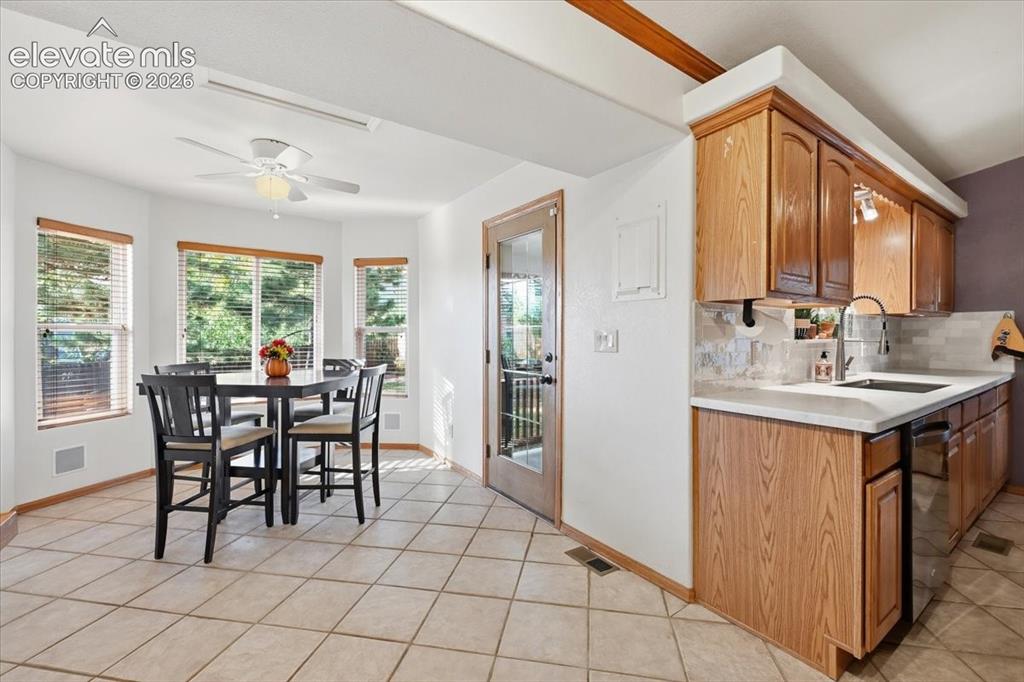 Image 9 of 25: Kitchen featuring wood-finish cabinetry, light-toned countertop, stainless
