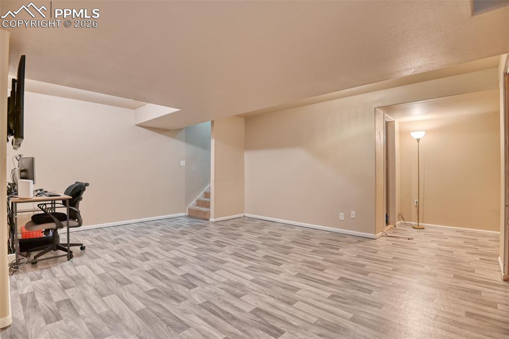 Image 21 of 35: Office space with light wood-style floors and baseboards