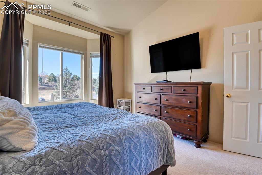 Image 24 of 35: Bedroom featuring light colored carpet