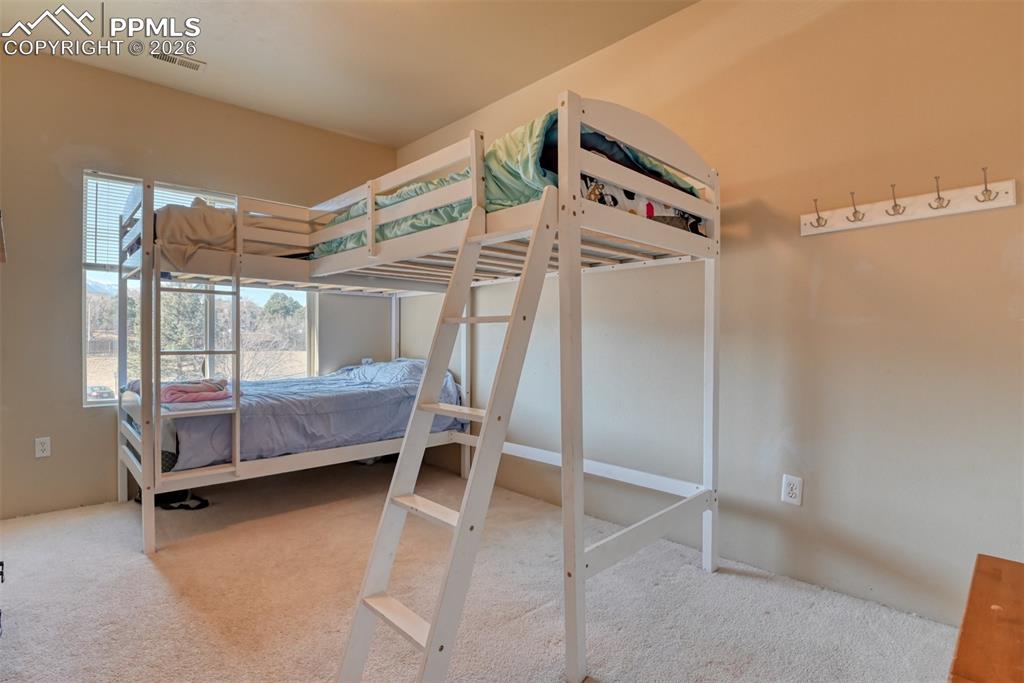 Image 29 of 35: Bedroom with light colored carpet
