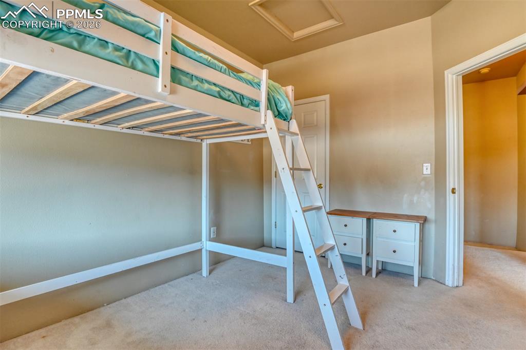 Image 31 of 35: Unfurnished bedroom featuring attic access