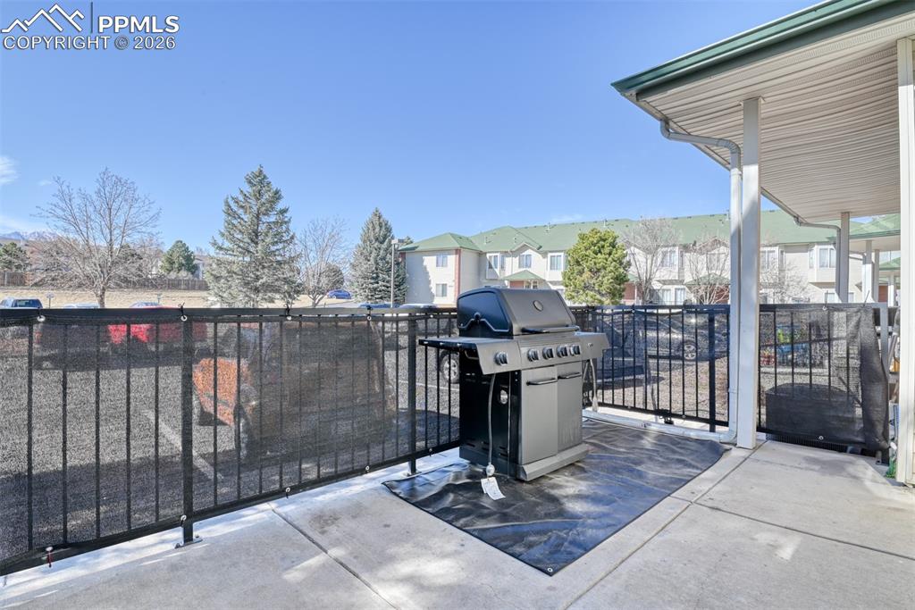 Image 34 of 35: View of patio with grilling area and a residential view