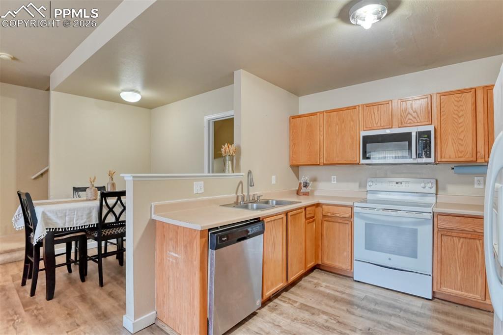 Image 9 of 35: Kitchen featuring stainless steel appliances, light countertops, light wood