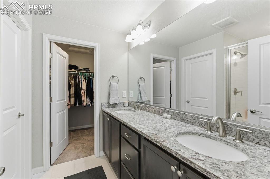 Image 18 of 38: Adjoining double vanity sink, shower and walk-in closeet in