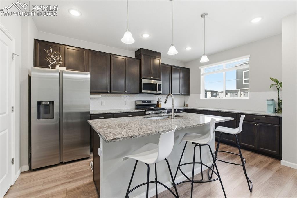 Image 7 of 38: Kitchen features a center iland w/counter bar