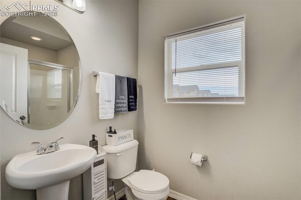 Image 11 of 27: Bathroom with toilet and an enclosed shower