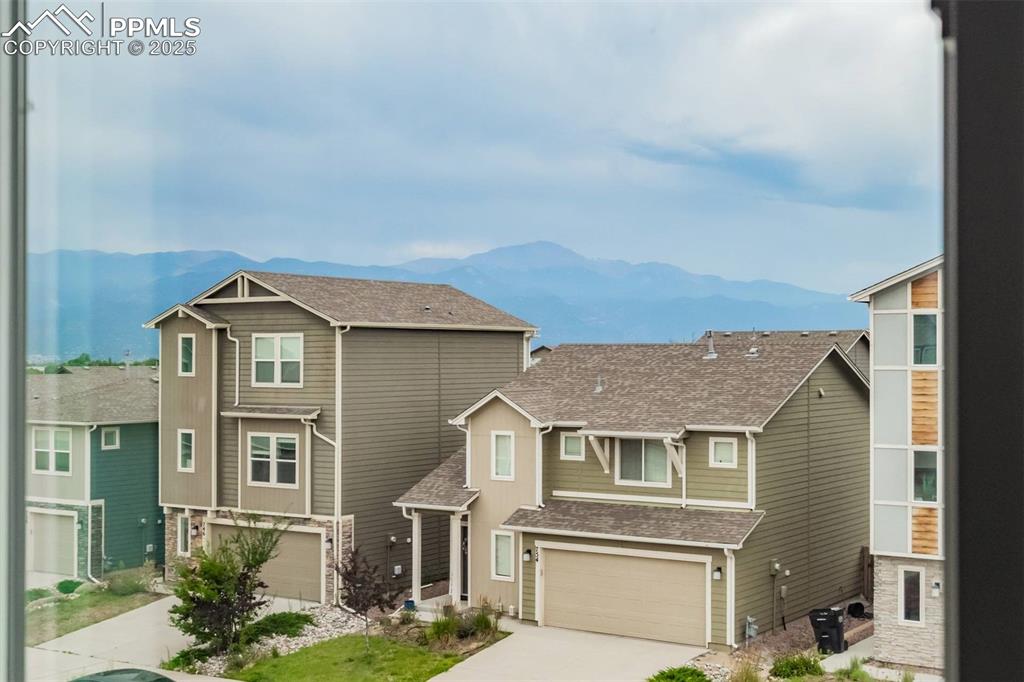 Image 14 of 27: Craftsman-style home with a garage, a mountain view, concrete driveway, and