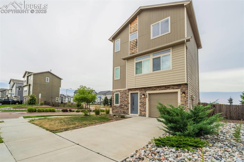 Image 2 of 27: View of front of property featuring an attached garage, concrete driveway,