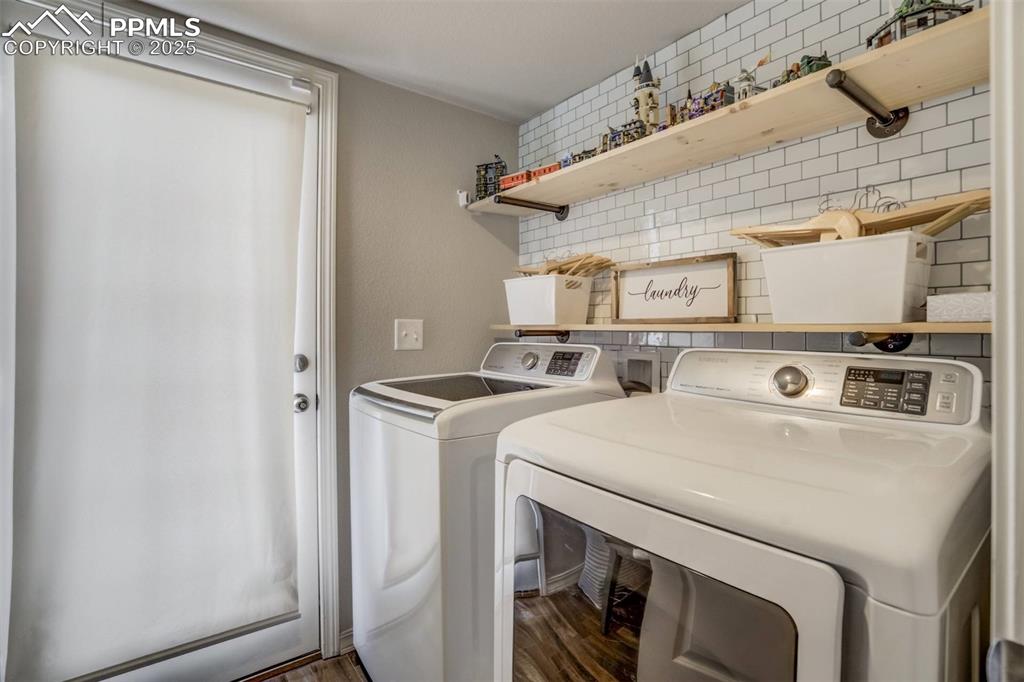 Image 23 of 27: Laundry area with washing machine and clothes dryer and wood finished floor