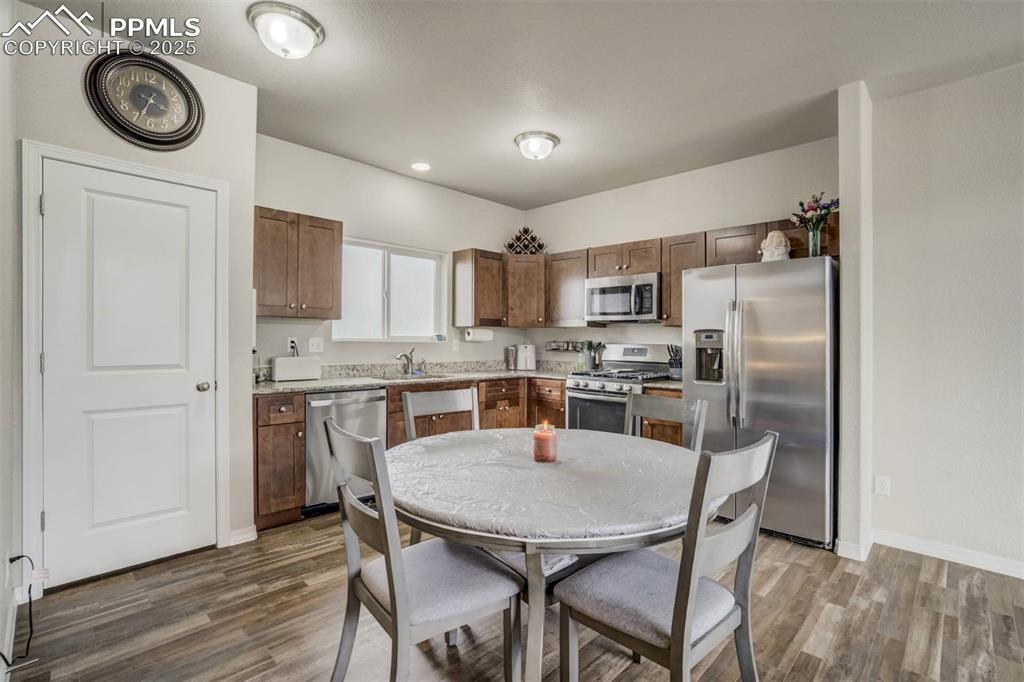 Image 7 of 27: Kitchen featuring stainless steel appliances, wood finished floors, and lig